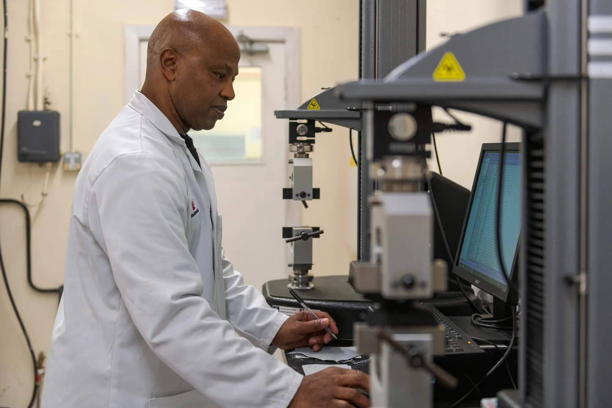 Man with lab coat on looking at screen